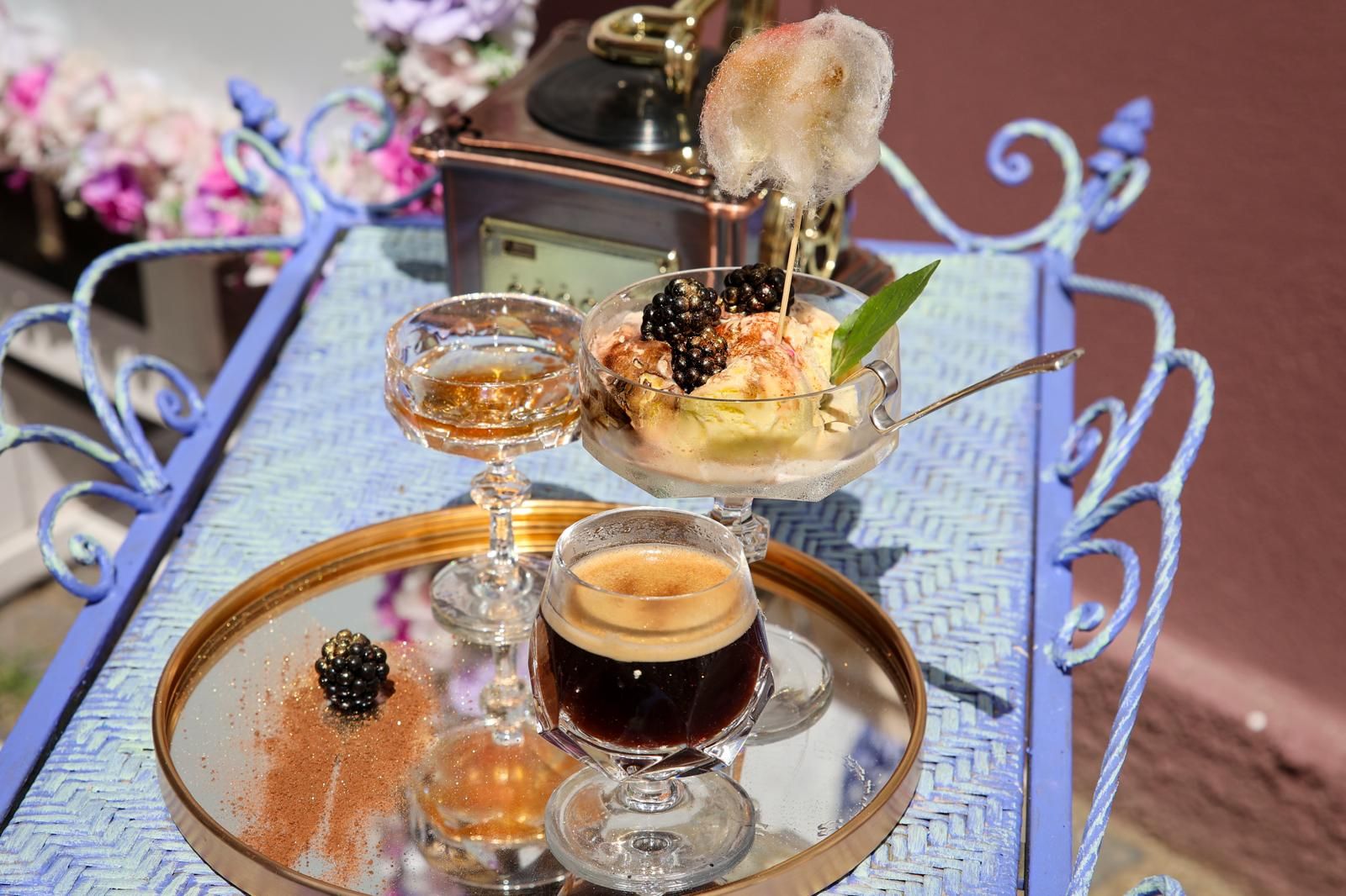 A steaming cup of tea on a table surrounded by potted greenery
